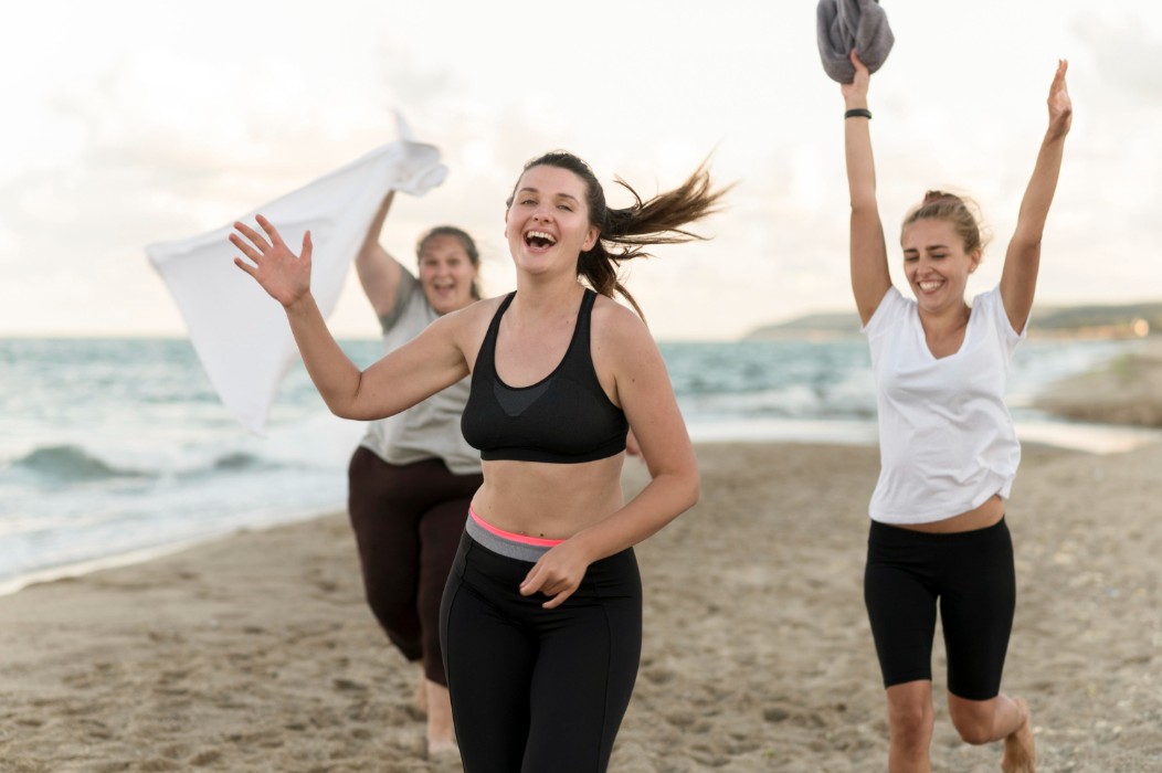 Joggers running across beach exercising